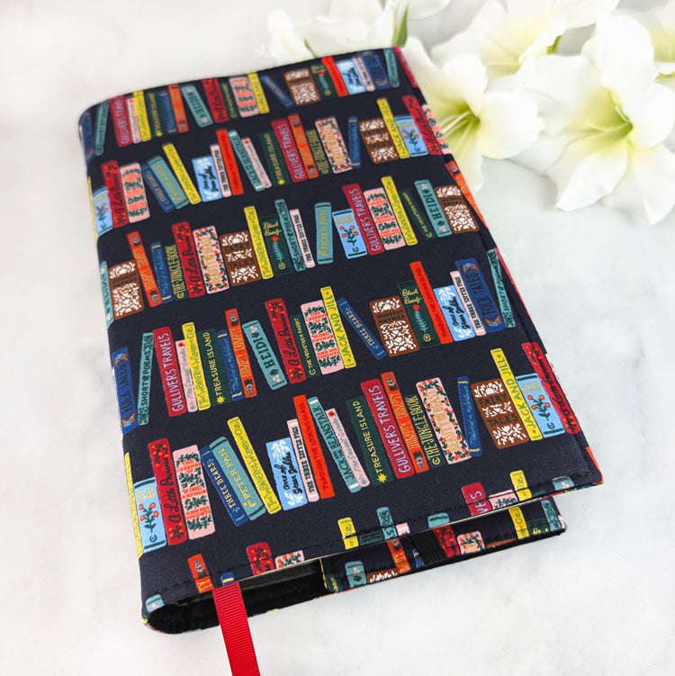 Navy blue book cover featuring colorful vintage-style book spines in red, yellow, and teal, creating a cozy classic library design.
