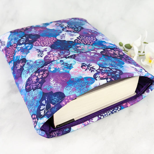 Fabric sleeve with a purple and blue floral medallion pattern, displayed on a white surface with white flowers.