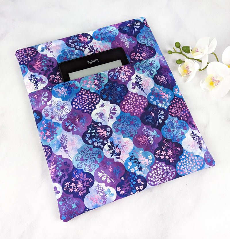 Fabric sleeve with a purple and blue floral medallion pattern, displayed on a white surface with white flowers.