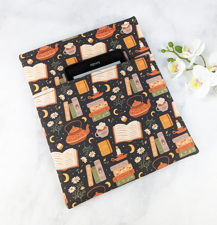 padded book sleeve, fabric features books, teapots, chamomile flowers and moons.