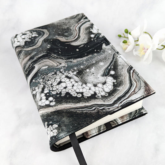Fabric book cover with a swirling black, gray, and white agate-inspired pattern, featuring crystalline details and a black ribbon bookmark.