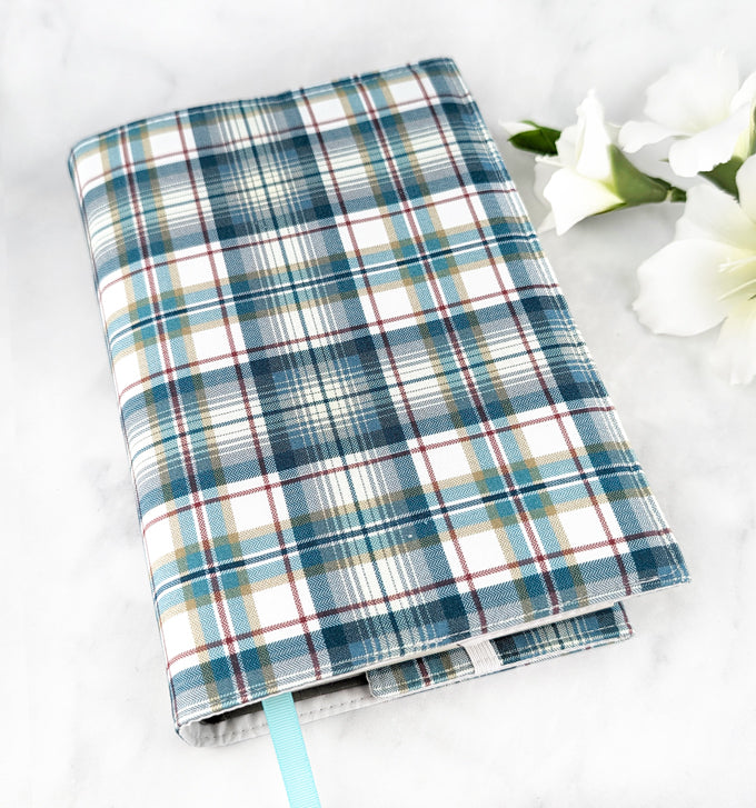 large adjustable fabric cover, fabric features plaid pattern in shades of teal, white and gray.