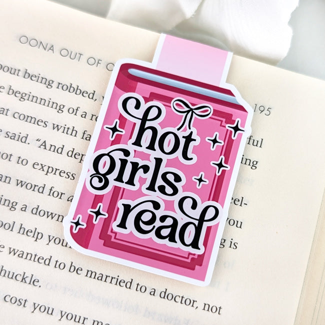 Magnetic bookmark shaped like a pink book with the phrase “Hot Girls Read” in bold black lettering surrounded by sparkles.