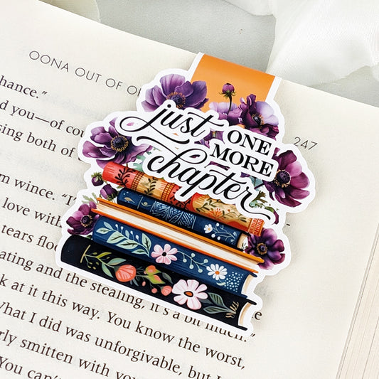 magnetic bookmark featuring a stack of vintage-style books adorned with 
flowers and the phrase "Just One More
Chapter" in elegant calligraphy.