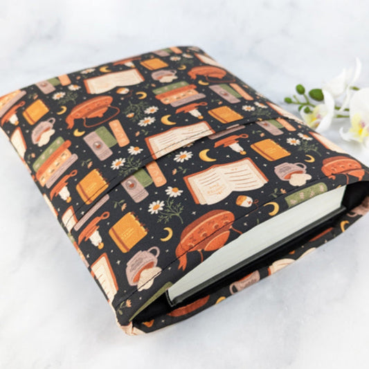 padded book sleeve, fabric features books, teapots, chamomile flowers and moons.