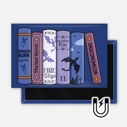 Rectangular navy magnet featuring a row of fantasy book spines in blue and purple tones, each with dragon-themed titles and illustrations.