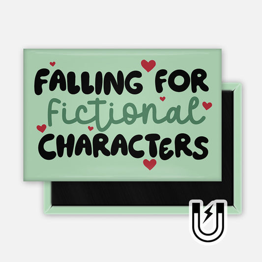 Rectangular green magnet with playful text that reads “Falling for Fictional Characters,” decorated with small red hearts.