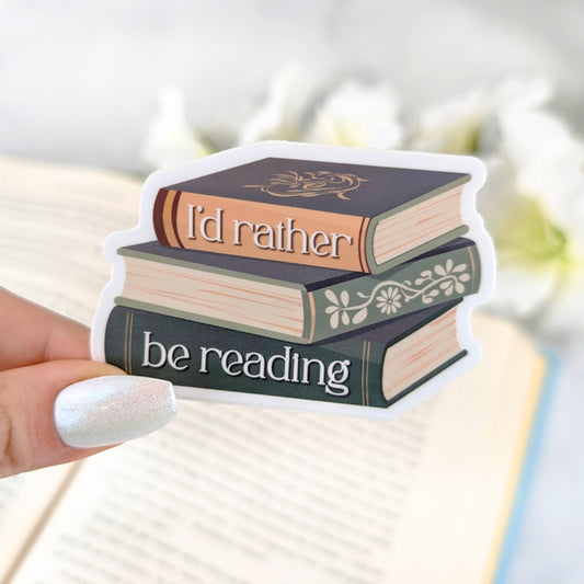 Illustrated sticker featuring a stack of vintage-style books with the text "I'd Rather Be Reading".