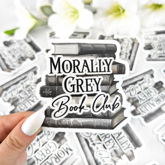 Vinyl sticker featuring a stack of vintage-style books in black and grey tones with the text “Morally Grey Book Club,” held by a hand with iridescent white nail polish.